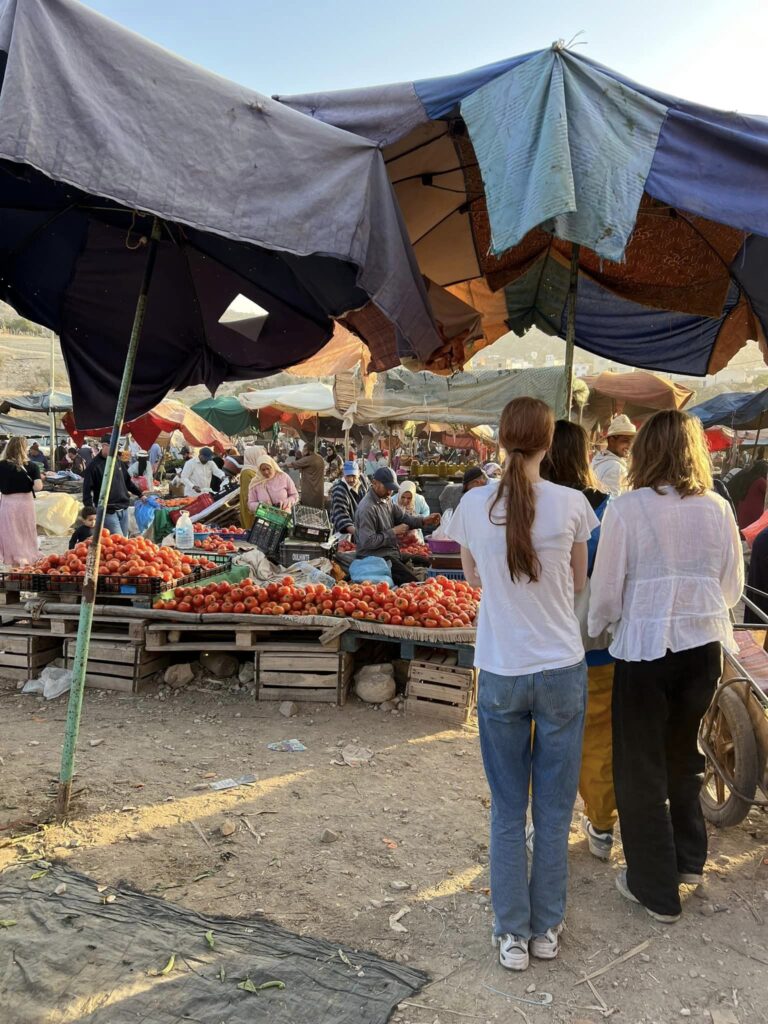 To piger står at kigger på et marked i Morokko
