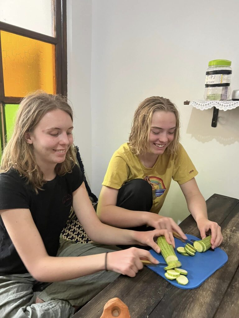 two girls slicing cucumber