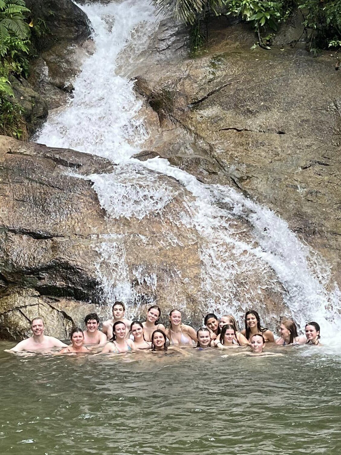 Students gathered in front of waterfall