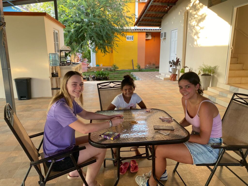 Two Danish girls sit with a younger girl around a table