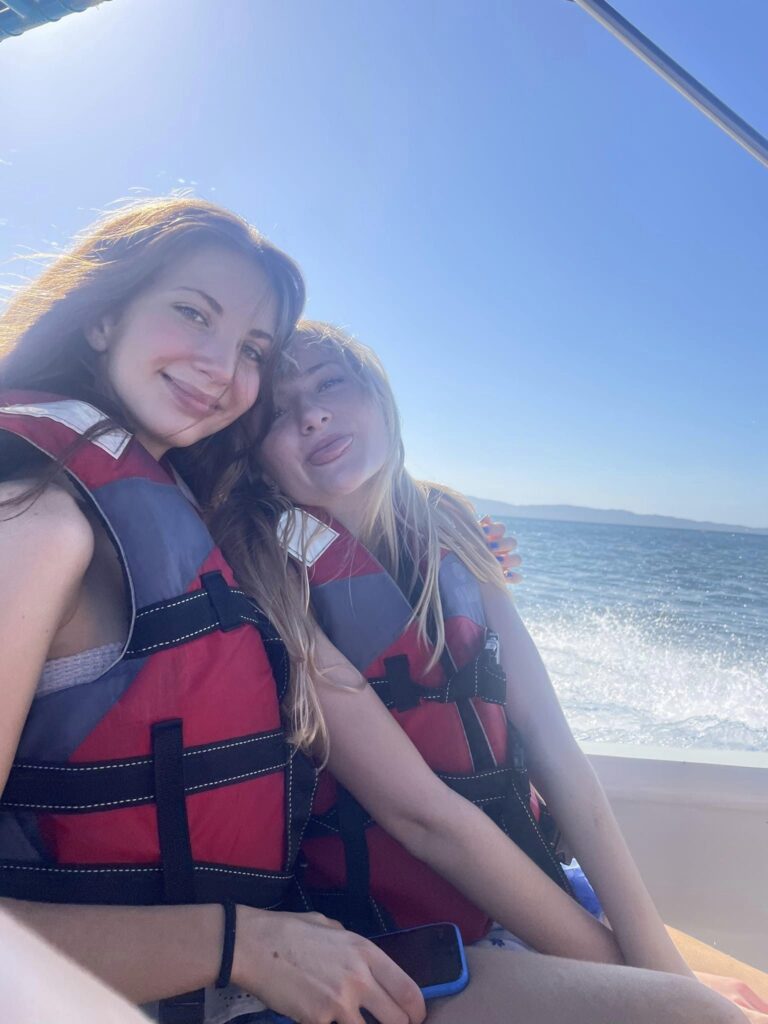 two girls hold each other while wearing life jackets