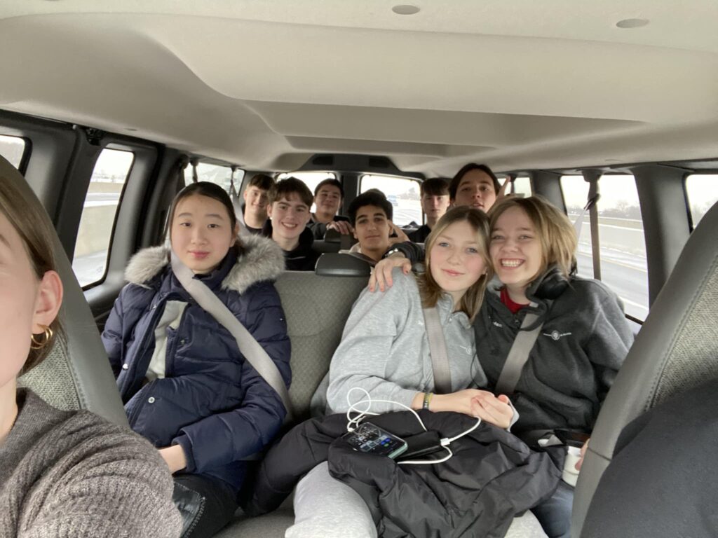 After-school students sit in a car and smile