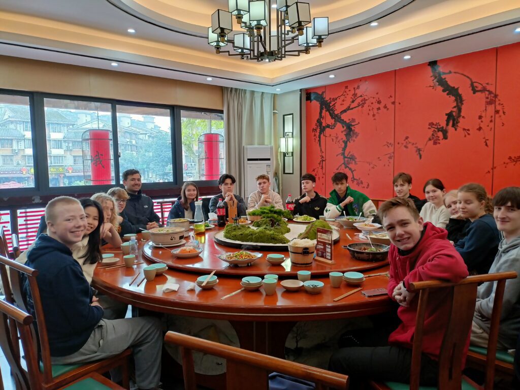 After-school students sit around a table eating Chinese food