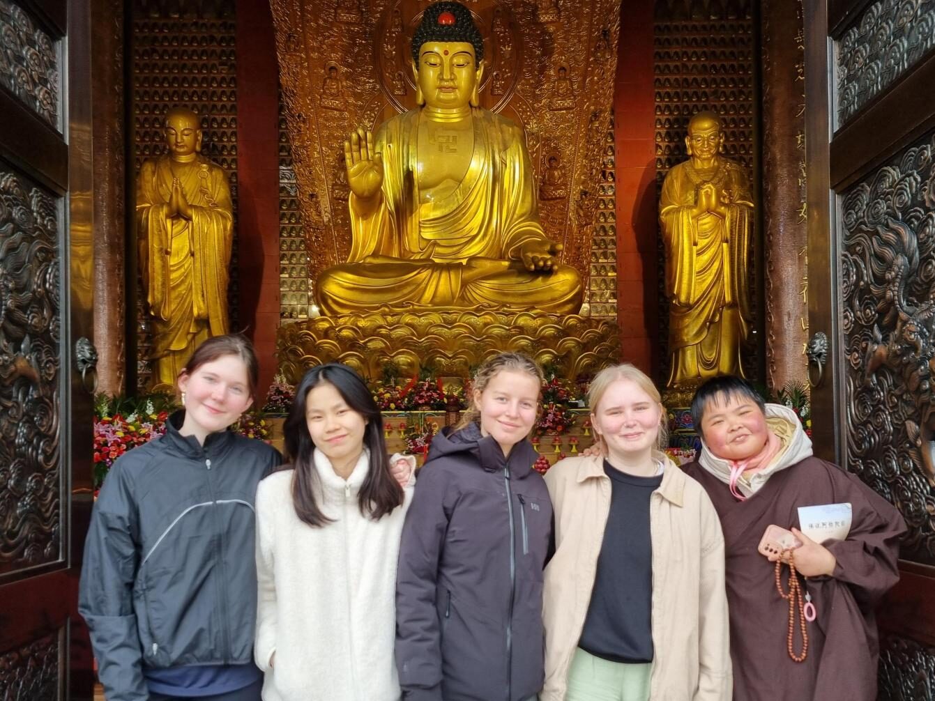 Five girls stand in front of a budda in China