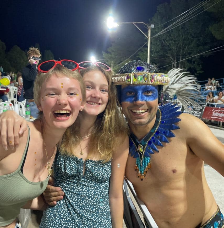 2 girls stand with a man from a parade who is painted blue in the face