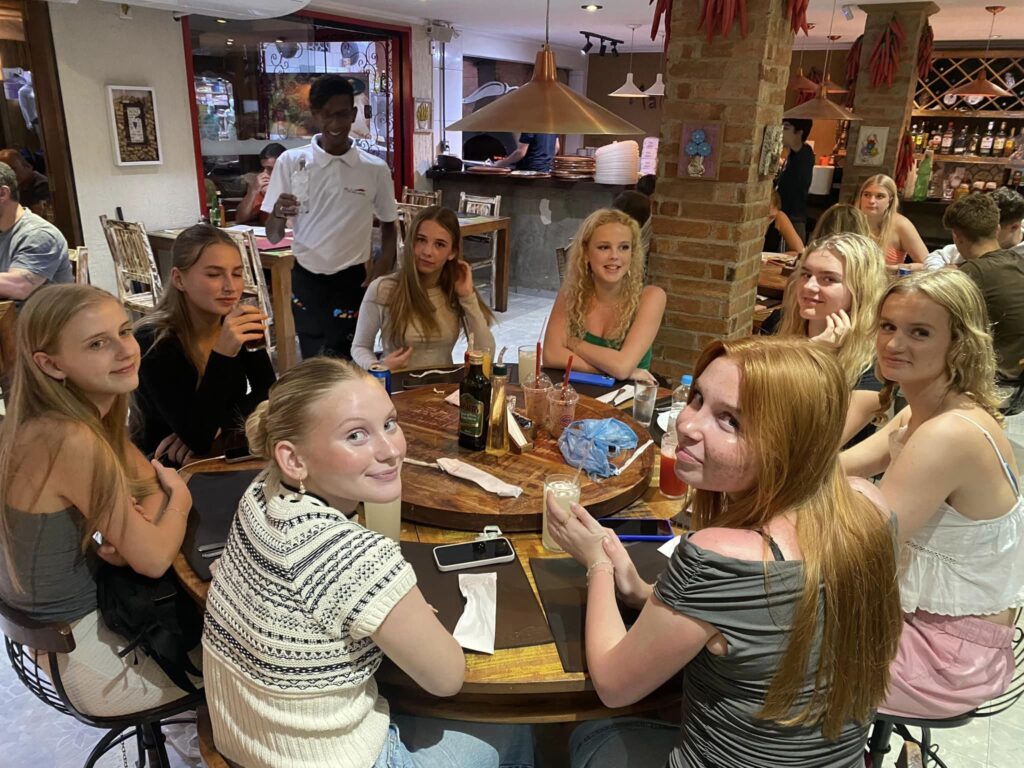 Girls sit around a table to socialise and eat.