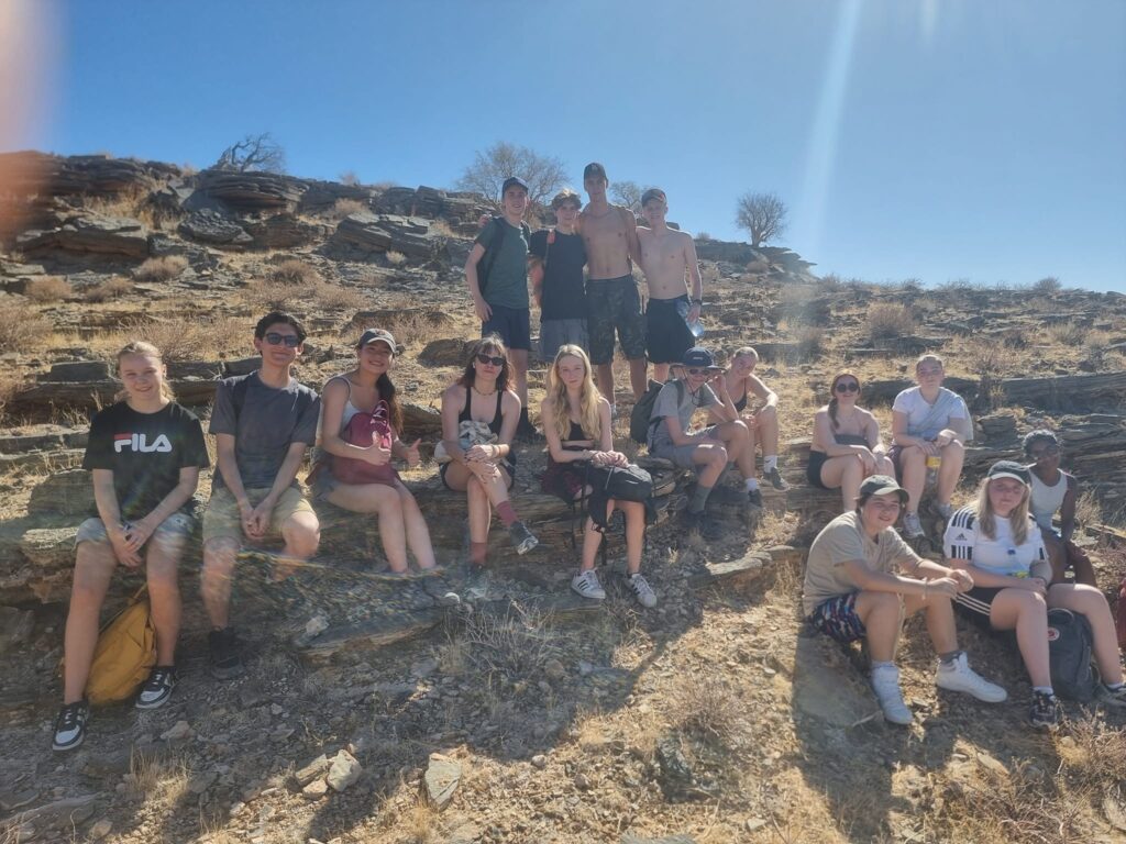 Students gathered in front of high cliff in Nimibia