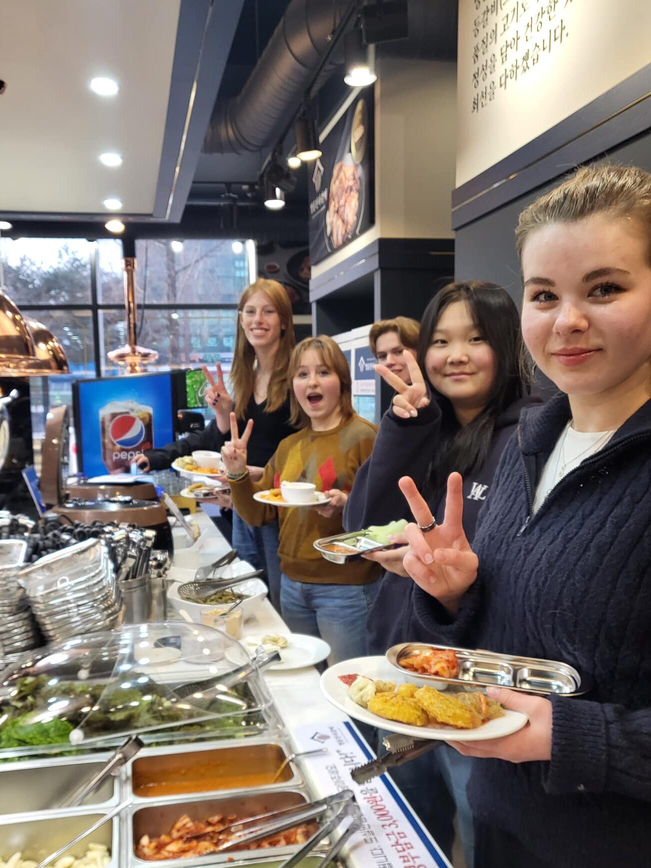 Elever tager aftensmad fra en koreansk buffet 