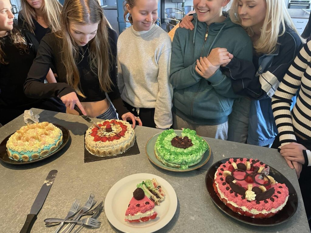 three girls cutting a cake