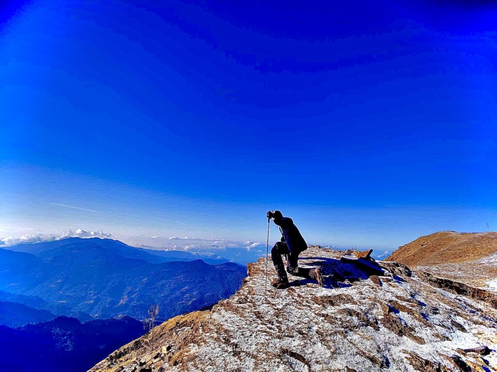 boy standing on a mountain looking out over the