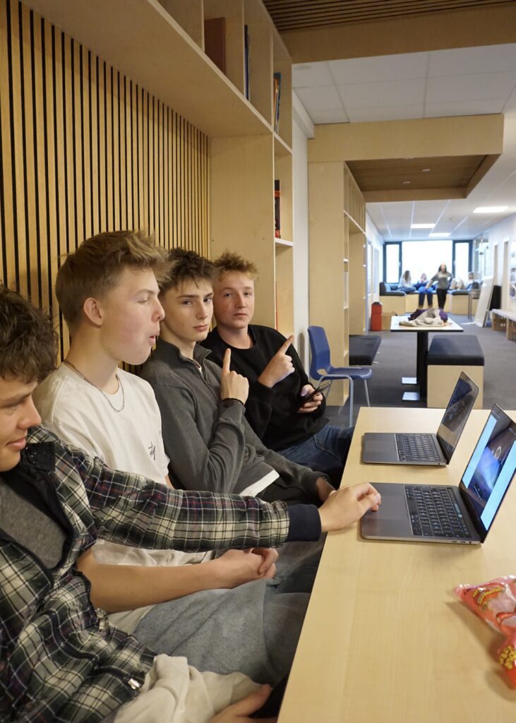 Four boys from Ranum Efterskole College sit in the corridor doing homework