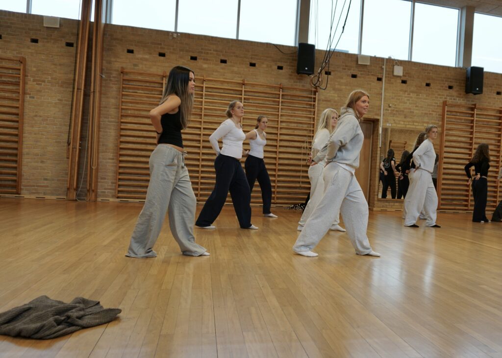 En gruppe af piger der danser i en gymnastiksal