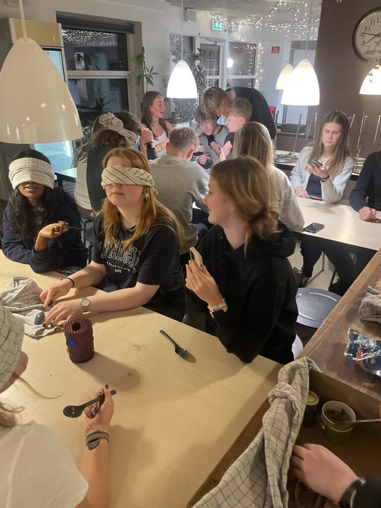 A large group of students sitting together and blindfolded