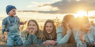 Children lying on their stomachs with a sunset